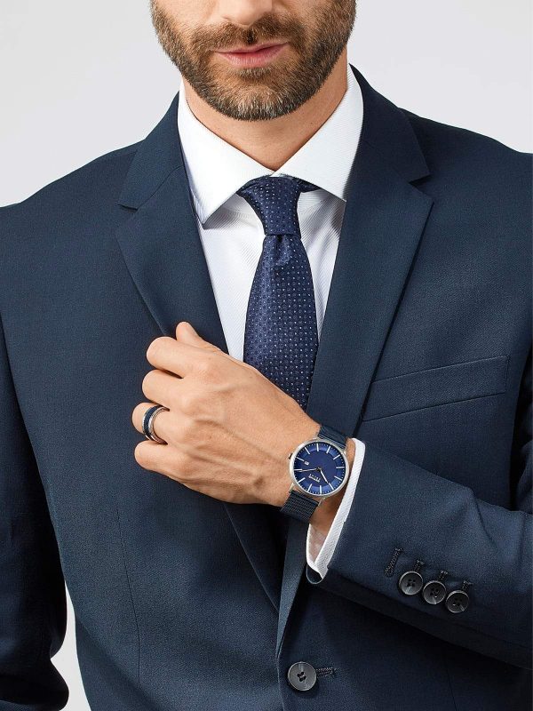 Hombre de traje mostrando reloj azul